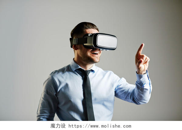 一个灰色的背景上一位身穿衬衫的男性正在使用VR眼镜